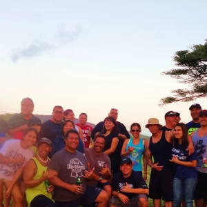 A diverse group of individuals smiling and posing together for a photograph in a cheerful setting.